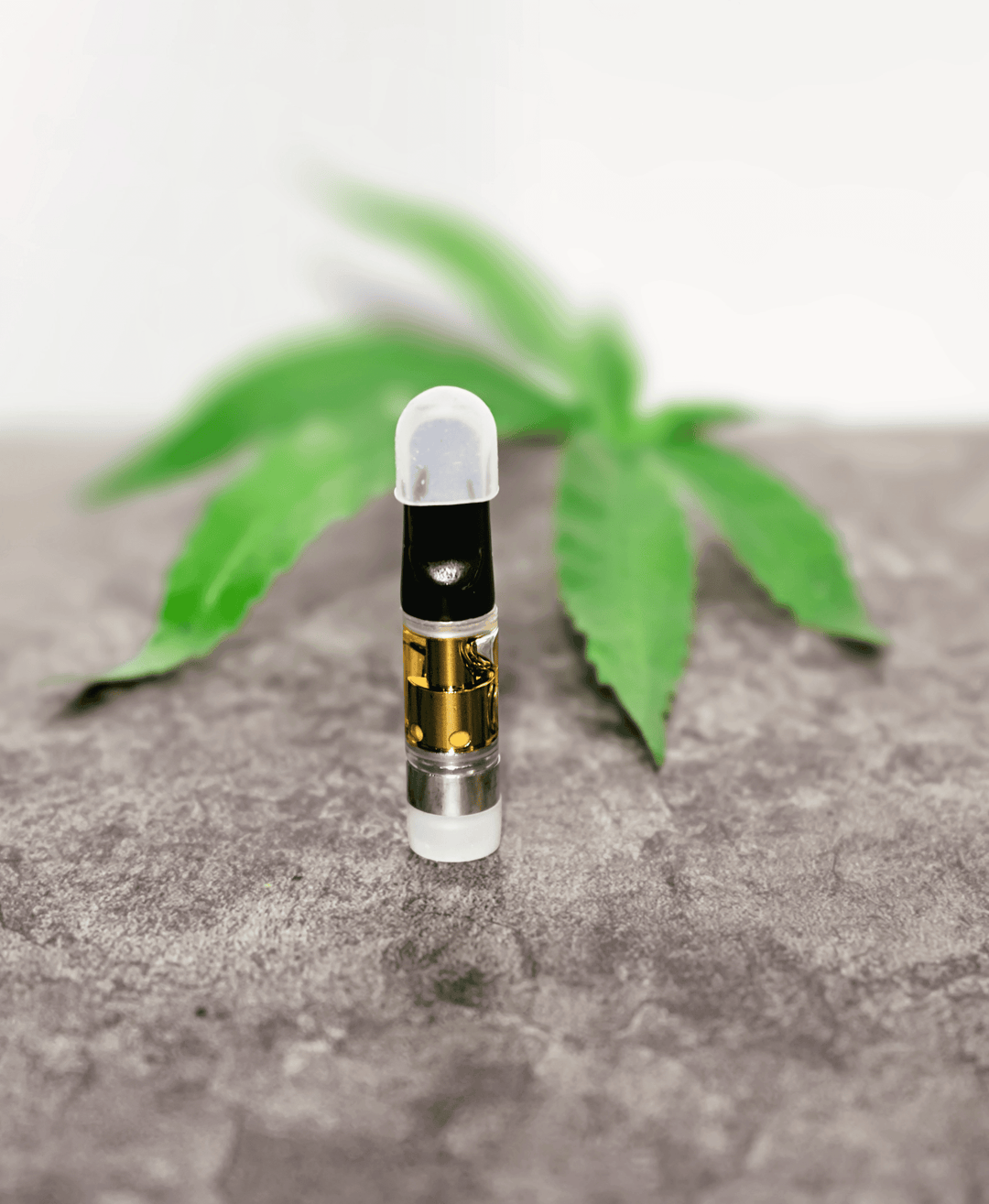 Frasco de HHC Liquid sobre una mesa con una hoja de cannabis al fondo